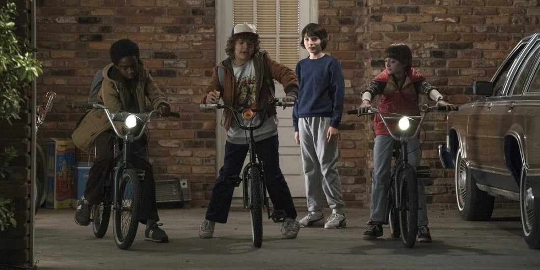 Drei Kinder auf Fahrrädern umringen einen Jungen im blauen Sweatshirt: Wer ist die Hauptfigur von Stranger Things?