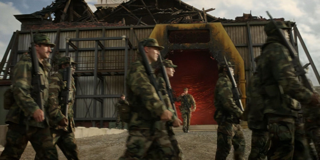 Soldaten in Tarnkleidung vor einer roten Öffnung, in einem Gebäude mit abgerissenem Dach.