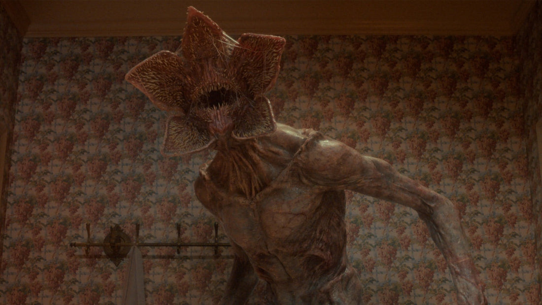 Der Demogorgon, mit offenem Maul, in einem Zimmer mit Blumentapete