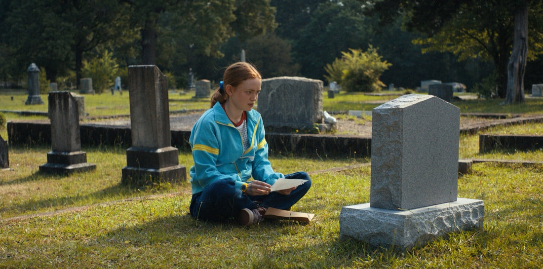 Max sitzt auf einem Friedhof, ein offener Brief auf den Knien, Stranger Things Staffel 4 Folge 4
